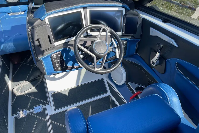 Slide: The Image of 2022 Centurion Ri230 boat cockpit with modern steering wheel and dual touchscreen displays. - 3