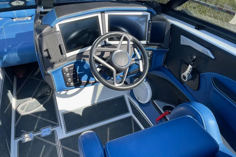 Slide: The Image of 2022 Centurion Ri230 boat dashboard with dual screens and blue interior. - 4
