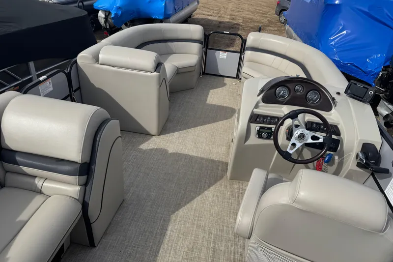 Slide: The Image of 2018 South Bay 200 pontoon boat interior with beige seating and steering console. - 12