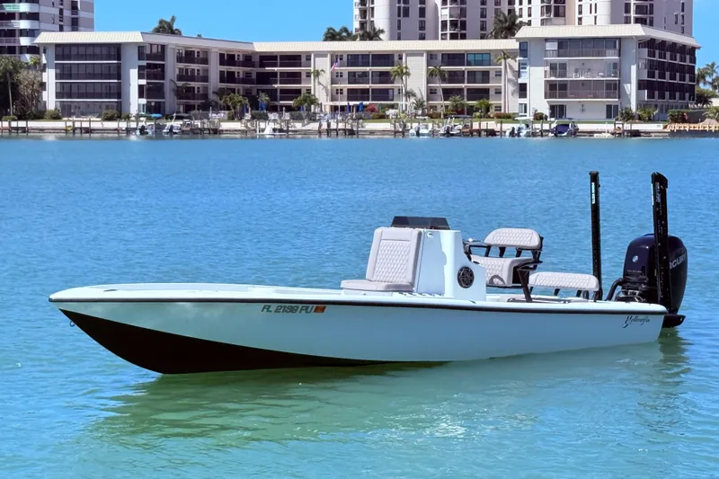 The Image of 2014 Yellowfin 24 Bay boat on calm water with buildings in the background. - 0