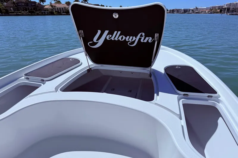 Slide: The Image of 2014 Yellowfin 24 Bay boat with open storage compartment on calm water. - 11
