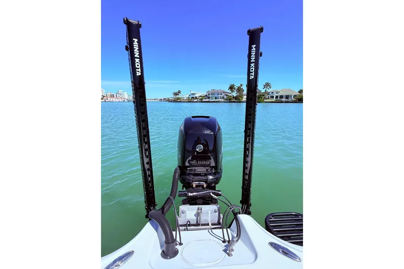 Slide: The Image of 2014 Yellowfin 24 Bay boat with Minn Kota poles on a serene waterway. - 3