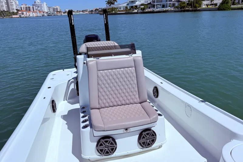 Slide: The Image of 2014 Yellowfin 24 Bay boat with cushioned seating on calm water. - 6