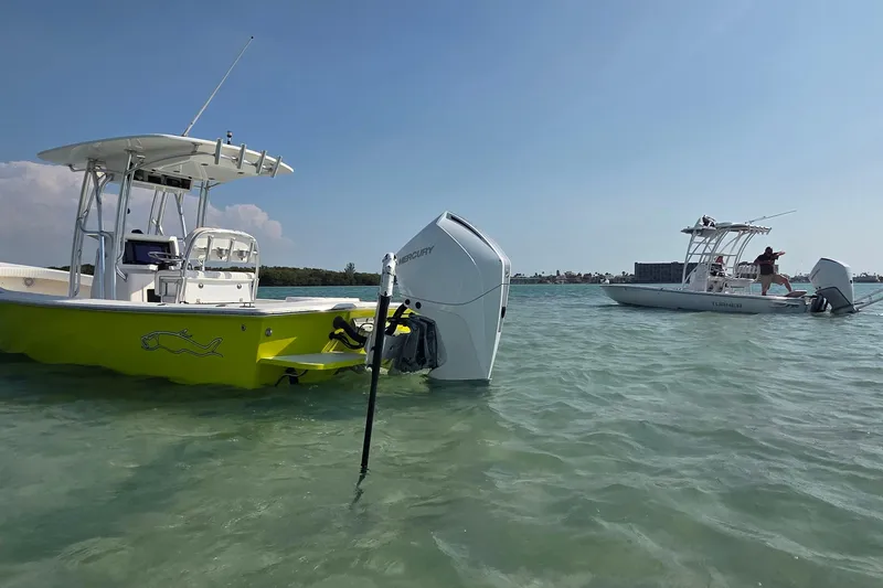 Slide: The Image of Two center console boats anchored in shallow water, featuring a 2012 Gause Built 26 model. - 14