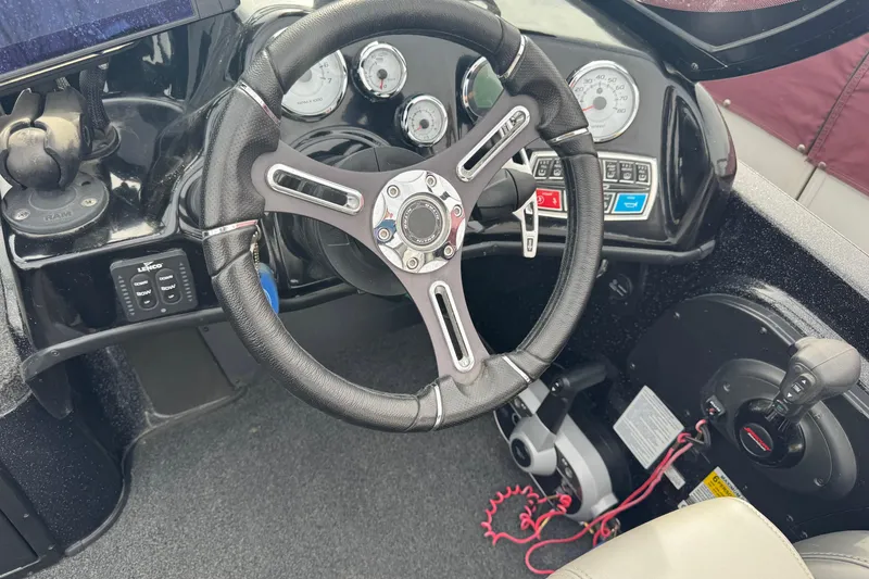 Slide: The Image of Steering wheel and dashboard of a 2018 Nitro ZV21 boat, featuring gauges and controls. - 8