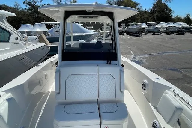 Slide: The Image of 2026 Pursuit S 288 Sport boat with white seating and sleek design in a marina. - 10