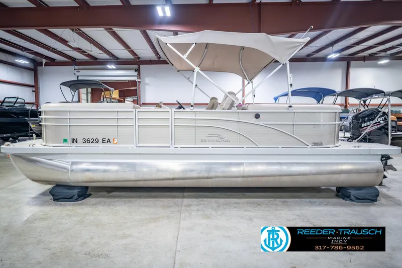 Slide: The Image of 2018 Bennington 23 SSRX pontoon boat in indoor showroom with canopy. - 11