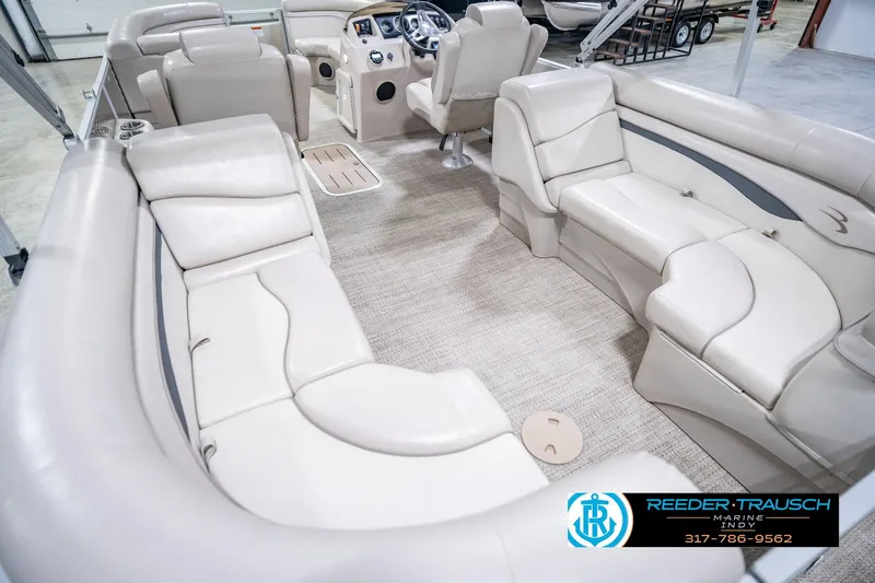 Slide: The Image of 2018 Bennington 23 SSRX pontoon boat interior with beige seating and steering console. - 15