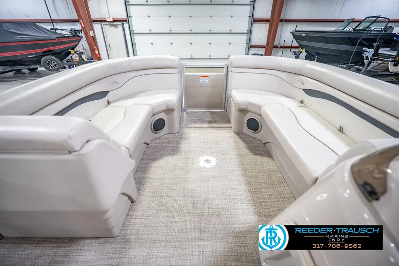 Slide: The Image of Interior of 2018 Bennington 23 SSRX pontoon boat with beige seating in a showroom. - 21