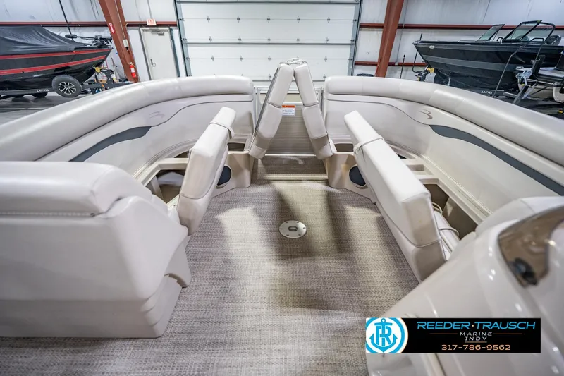 Slide: The Image of 2018 Bennington 23 SSRX pontoon boat interior with beige seating in a showroom. - 22