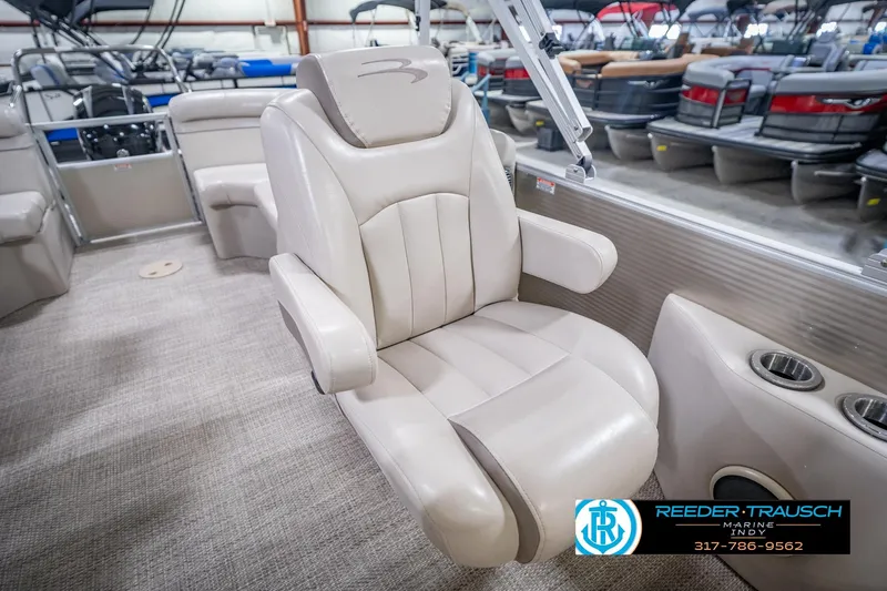 Slide: The Image of 2018 Bennington 23 SSRX boat interior with beige captain's chair and cup holders. - 26