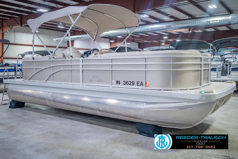 Slide: The Image of 2018 Bennington 23 SSRX pontoon boat in showroom, featuring canopy and sleek design. - 6