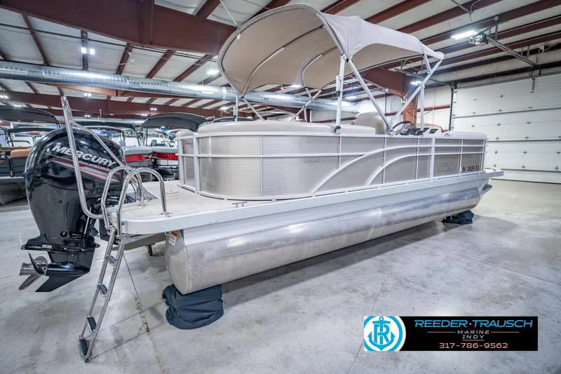 Slide: The Image of 2018 Bennington 23 SSRX pontoon boat in indoor storage with Mercury outboard motor. - 8
