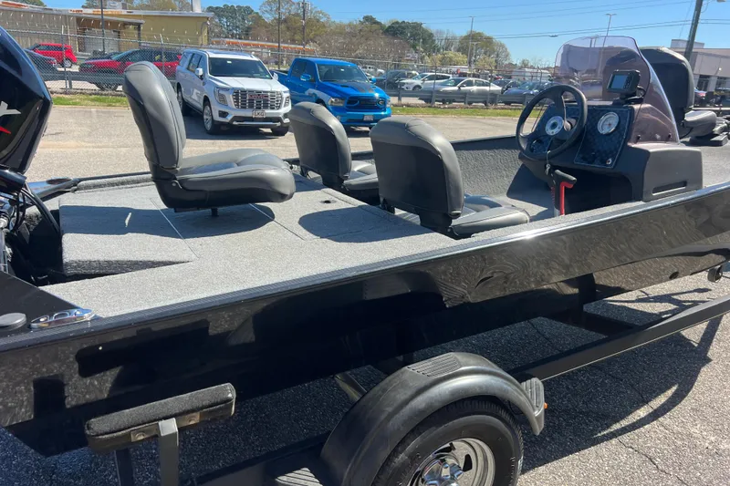 Slide: The Image of 2023 Tracker Bass Tracker Classic XL boat with seating and steering console, parked outdoors. - 59