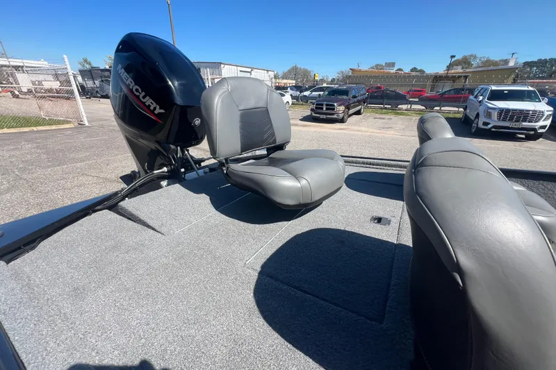 Slide: The Image of 2023 Tracker Bass Tracker Classic XL boat interior with Mercury engine, gray seating, and carpeted deck. - 70