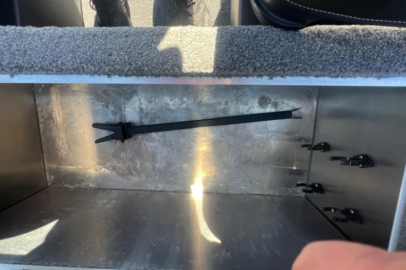 Slide: The Image of 2023 Tracker Bass Tracker Classic XL storage compartment with carpeted interior and securing straps. - 77