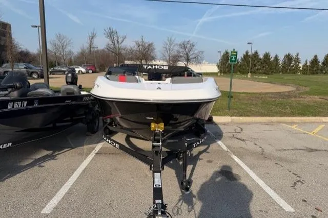 Slide: The Image of 2024 Tahoe T16 boat on trailer in parking lot, clear sky background. - 2