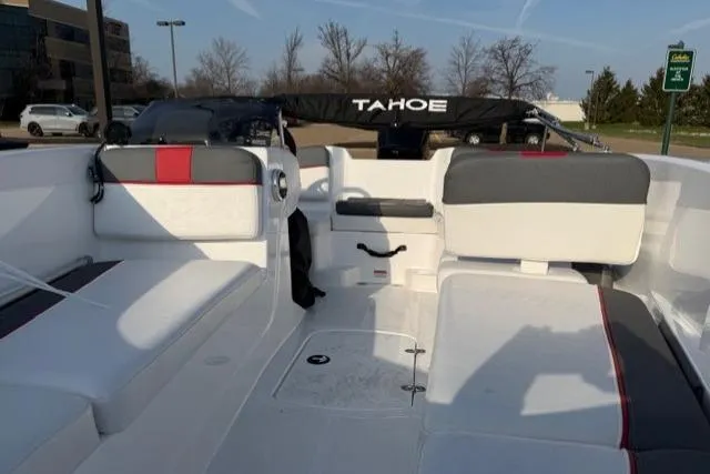 Slide: The Image of 2024 Tahoe T16 boat interior with white and gray seating, parked outdoors. - 5