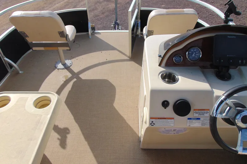 Slide: The Image of 2017 Lexington 317 pontoon boat interior with steering console and seating. - 12