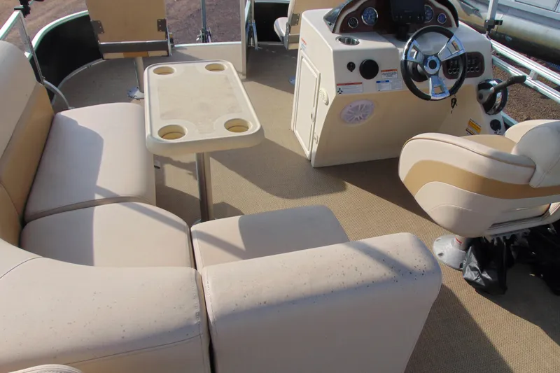Slide: The Image of 2017 Lexington 317 Pontoon interior with beige seating and steering console. - 15