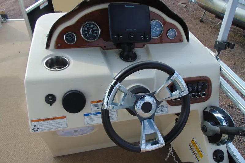 Slide: The Image of 2017 Lexington 317 Pontoon boat dashboard with steering wheel and gauges. - 16