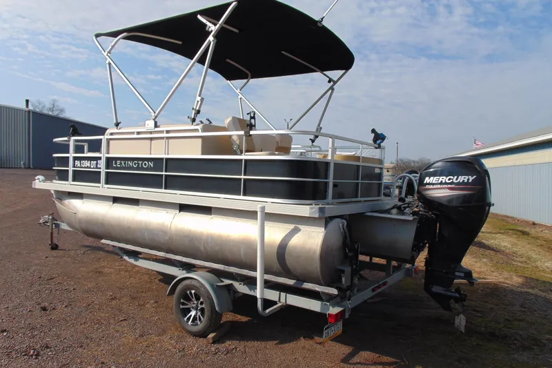 Slide: The Image of 2017 Lexington 317 pontoon boat with Mercury outboard motor on trailer. - 3