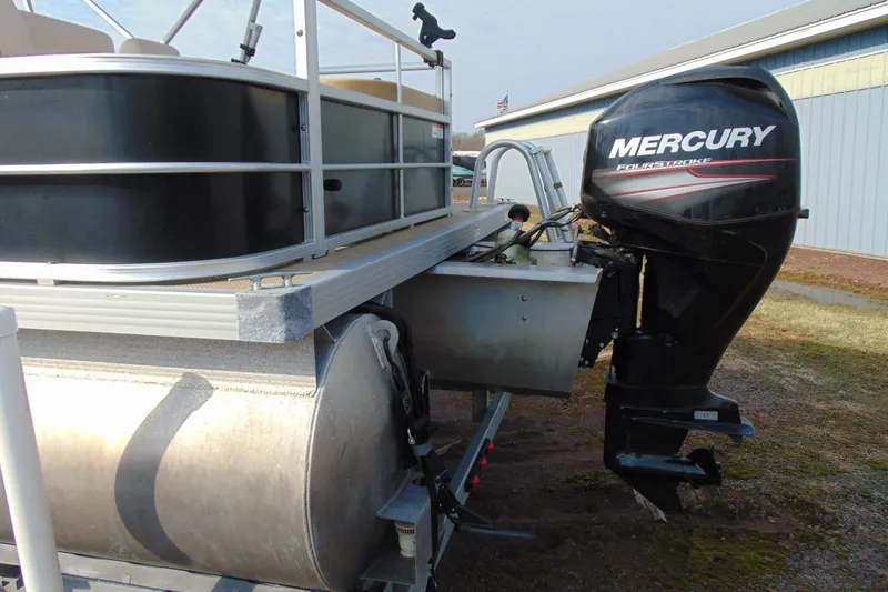 Slide: The Image of 2017 Lexington 317 pontoon boat with Mercury FourStroke engine, parked outdoors. - 5