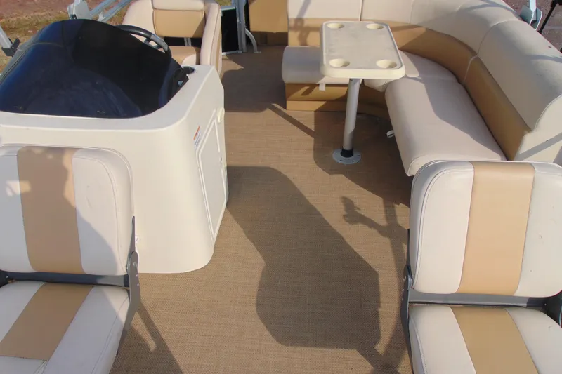 Slide: The Image of 2017 Lexington 317 pontoon boat interior with beige seating and table. - 8