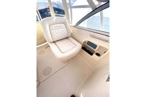 Slide: The Image of 2017 Grady-White Freedom 255 boat interior with cushioned seating and control panel. - 12