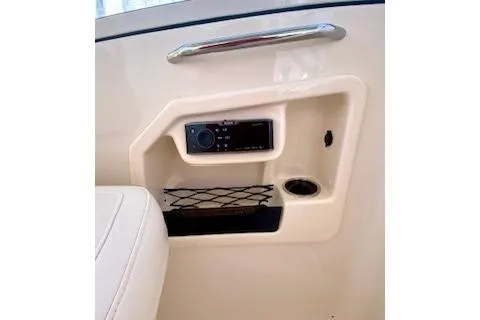 Slide: The Image of 2017 Grady-White Freedom 255 boat interior with storage compartment and audio controls. - 13