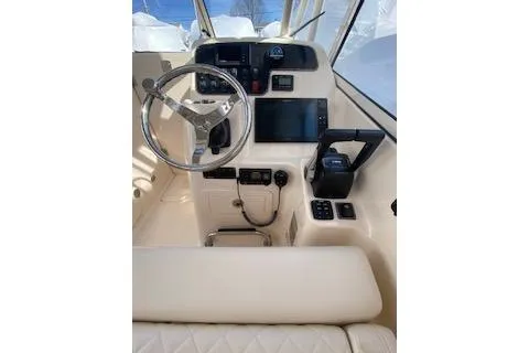 Slide: The Image of 2017 Grady-White Freedom 255 boat cockpit with steering wheel and controls. - 15