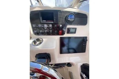 Slide: The Image of 2017 Grady-White Freedom 255 boat dashboard with navigation controls and display screens. - 16