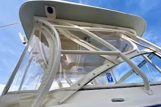 Slide: The Image of 2017 Grady-White Freedom 255 boat with clear canopy against blue sky. - 5