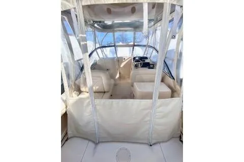 Slide: The Image of 2017 Grady-White Freedom 255 boat interior with seating and helm, enclosed by clear panels. - 8