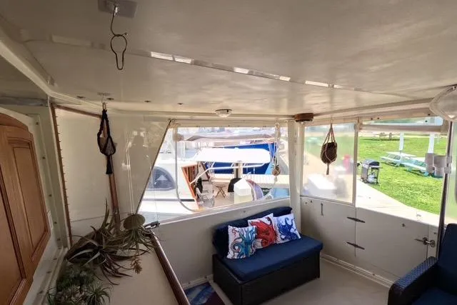 Slide: The Image of 1987 Californian 45 Motor Yacht interior with seating, plants, and marina view. - 12