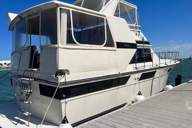 Slide: The Image of 1987 Californian 45 Motor Yacht docked, featuring spacious deck and classic design. - 3