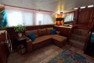 Slide: The Image of 1987 Californian 45 Motor Yacht interior with cozy seating, wooden accents, and decorative elements. - 35