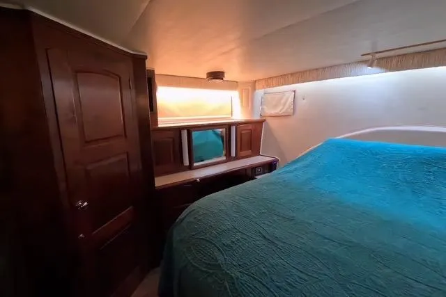 Slide: The Image of 1987 Californian 45 Motor Yacht interior with wood cabinetry and blue bedding. - 43