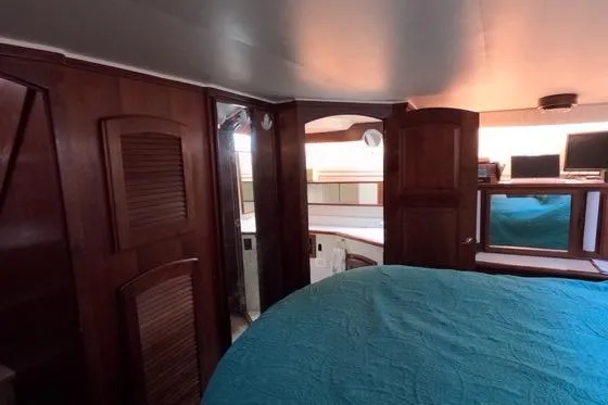 Slide: The Image of 1987 Californian 45 Motor Yacht interior with wood paneling and blue bedding. - 46
