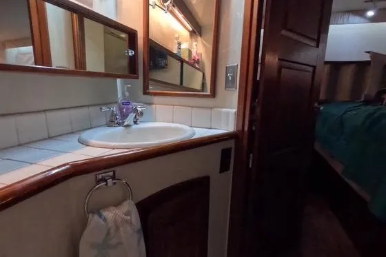 Slide: The Image of 1987 Californian 45 Motor Yacht bathroom with sink, mirror, and wooden accents. - 57