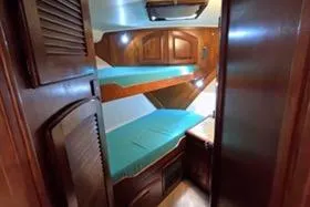 Slide: The Image of 1987 Californian 45 Motor Yacht cabin with wooden interior and bunk beds. - 58