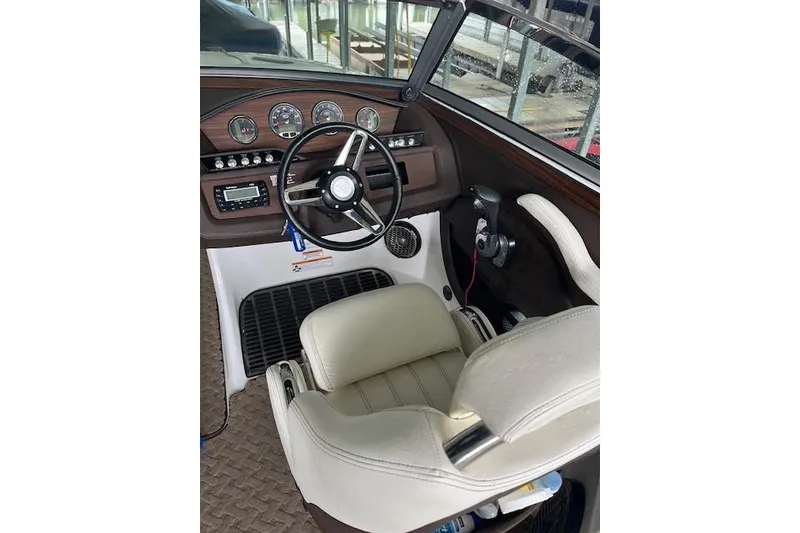 Slide: The Image of Interior of a 2014 Cobalt R5 boat, featuring steering wheel and dashboard controls. - 14