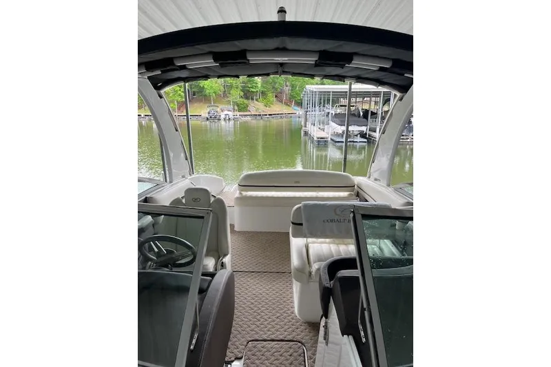 Slide: The Image of Interior view of a 2014 Cobalt R5 boat docked at a serene lakeside. - 18