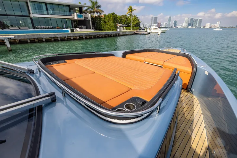 Slide: The Image of 2022 Cranchi A46 Luxury Tender with orange sunbed, docked near modern waterfront property. - 40