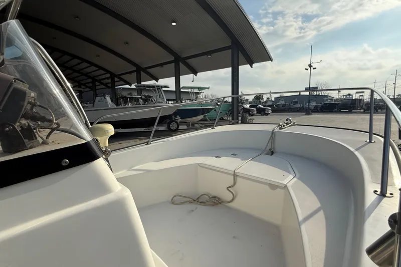 Slide: The Image of 2005 Boston Whaler 17 Montauk boat docked under a covered marina. - 11