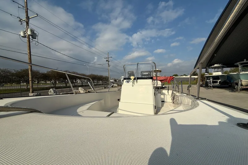 Slide: The Image of 2005 Boston Whaler 17 Montauk boat under a partly cloudy sky at a marina. - 13