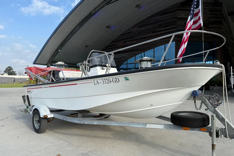 Slide: The Image of 2005 Boston Whaler 17 Montauk boat on trailer, parked near modern building. - 3