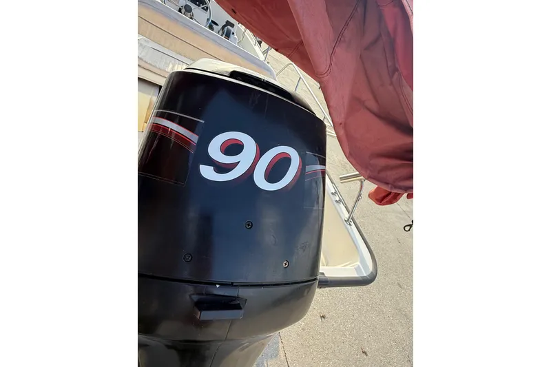 Slide: The Image of Outboard motor on a 2005 Boston Whaler 17 Montauk boat, featuring a "90" decal. - 7