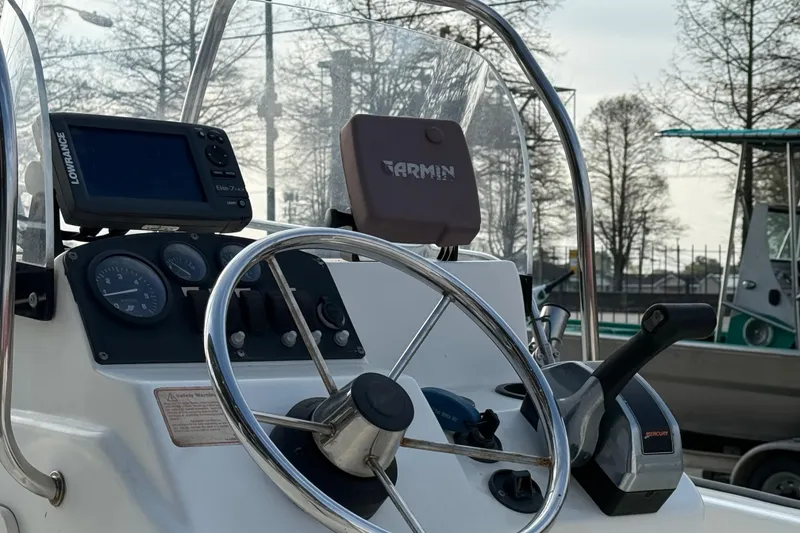 Slide: The Image of 2005 Boston Whaler 17 Montauk boat dashboard with steering wheel and navigation equipment. - 8