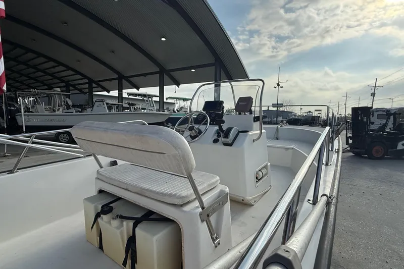 Slide: The Image of 2005 Boston Whaler 17 Montauk boat at marina, featuring console and seating. - 9